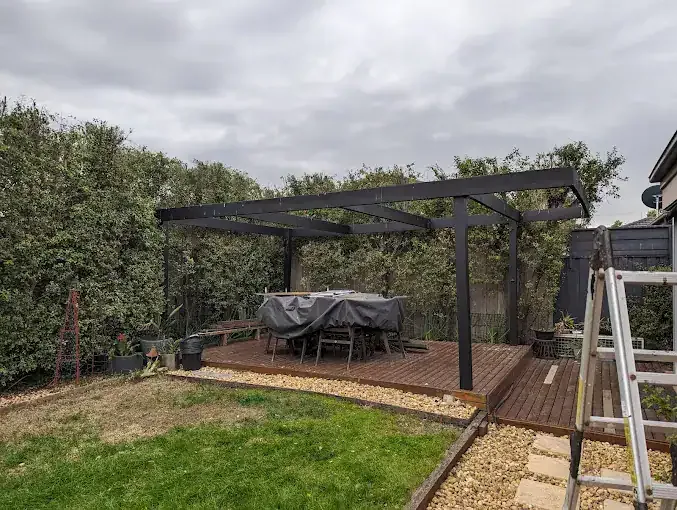 Hedge shaped around a backyard pergola
